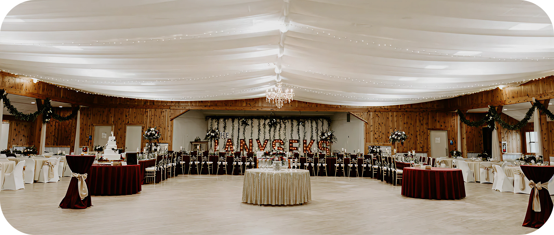 Elegant indoor wedding reception with draped ceiling.